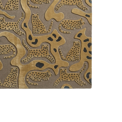 A close-up of a textured rug featuring a pattern of stylized leopard and cheetah cat silhouettes in tan and brown with black spots, set against a taupe-gray background.