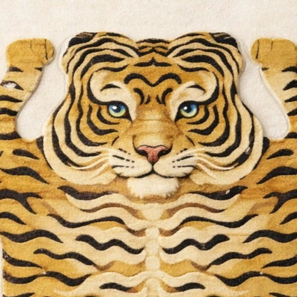A close-up of a tiger-themed rug or textile featuring a stylized tiger face and body with black stripes on a tan and cream background, shown against a light neutral backdrop.
