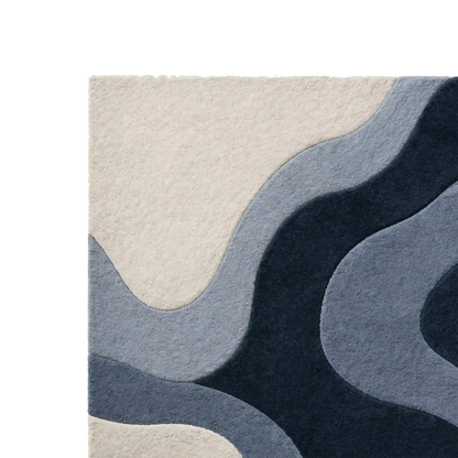 Abstract area rug with layered wavy organic shapes in cream, light blue, medium blue, and dark navy, shown cropped on a white background.