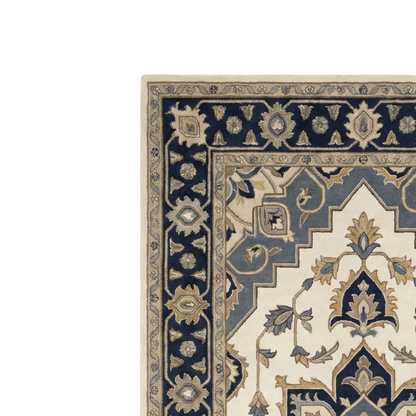 A close-up corner view of a traditional patterned area rug with a cream field, navy blue border, and beige floral motifs.