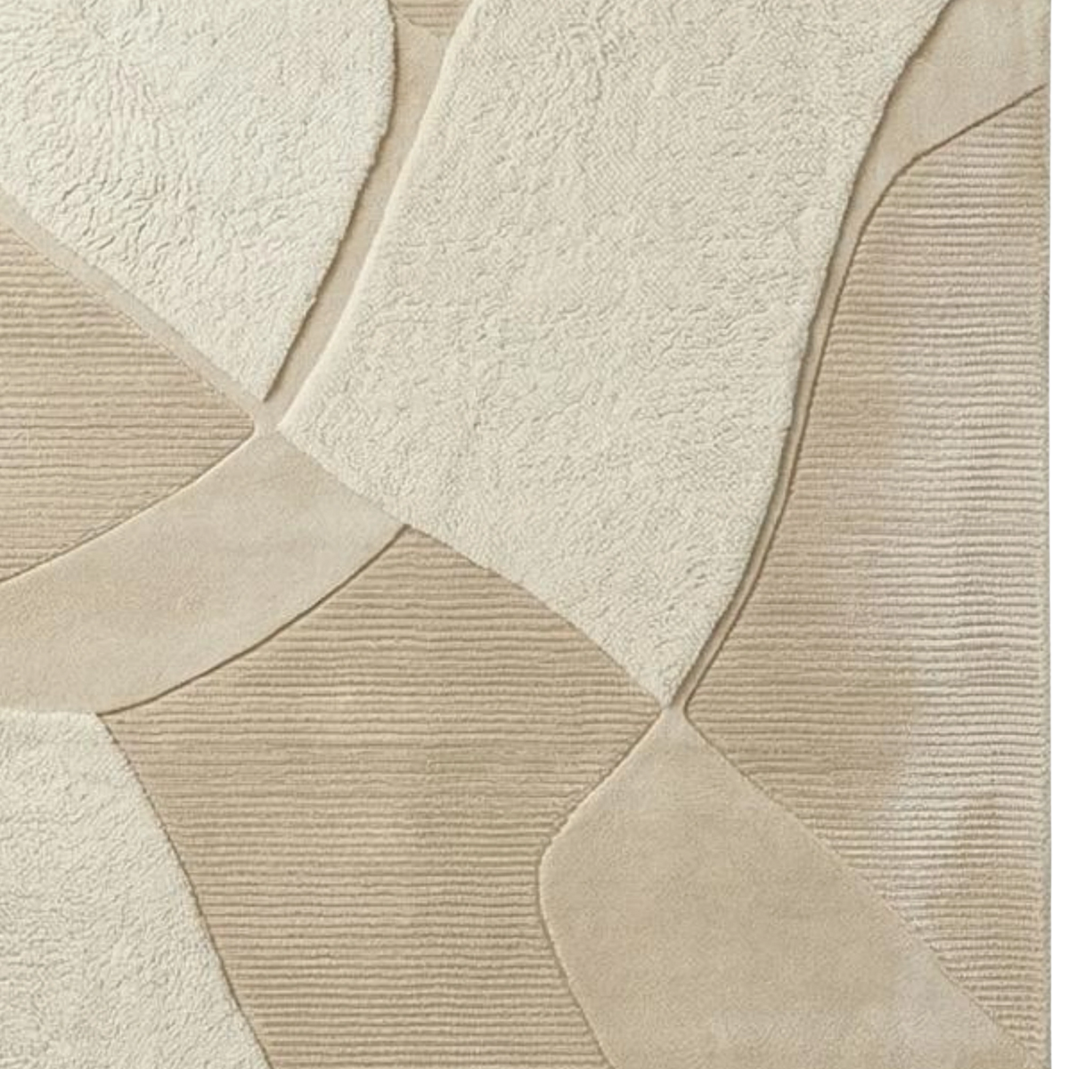 A close-up of a beige and cream textured rug with a geometric patchwork design, featuring a mix of plush, looped, and ribbed textures.
