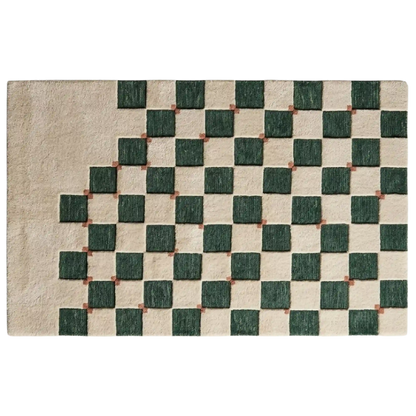 A rectangular area rug with a textured geometric pattern featuring dark green squares on a warm beige background, with small brown accents at the intersections.