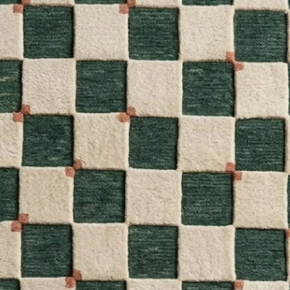 A close-up of a textured fabric or rug pattern featuring a checkered design with dark green and cream squares separated by thin terracotta-colored lines.