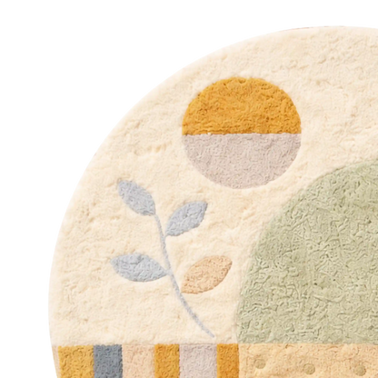 Close-up of a round rug with a minimalist abstract design, featuring a mustard yellow and light gray sun, a pale green oval shape, a gray and peach leaf motif, and a striped border at the bottom on a white background.