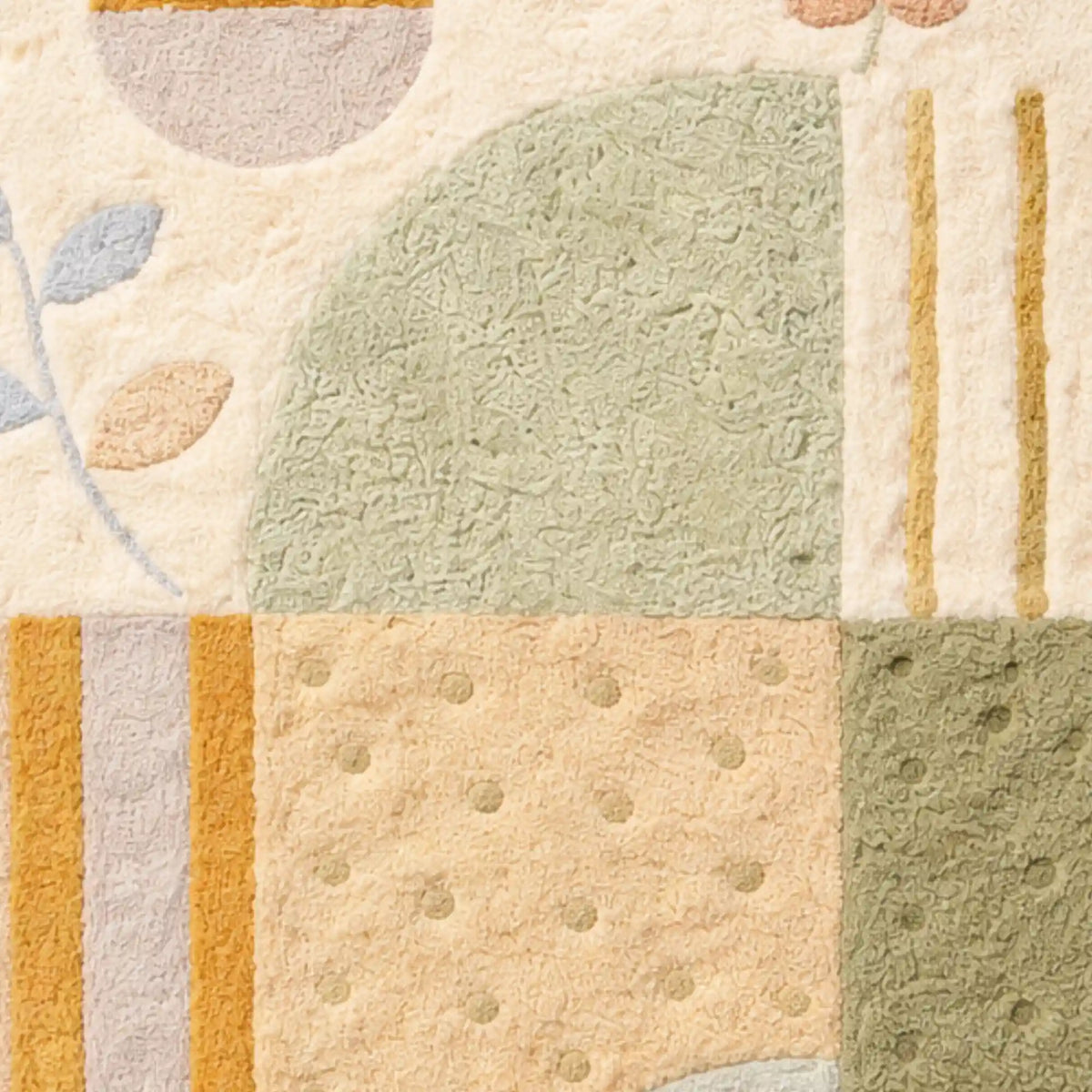 A close-up of a textured area rug with a patchwork design in muted sage green, cream, beige, and mustard yellow tones.