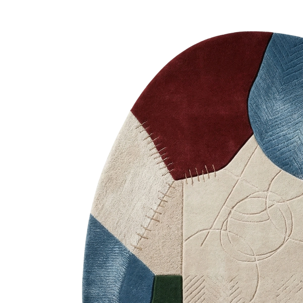 Close-up of a patchwork rug with geometric color blocks in burgundy, cream, blue, and a small dark green section on a white background.