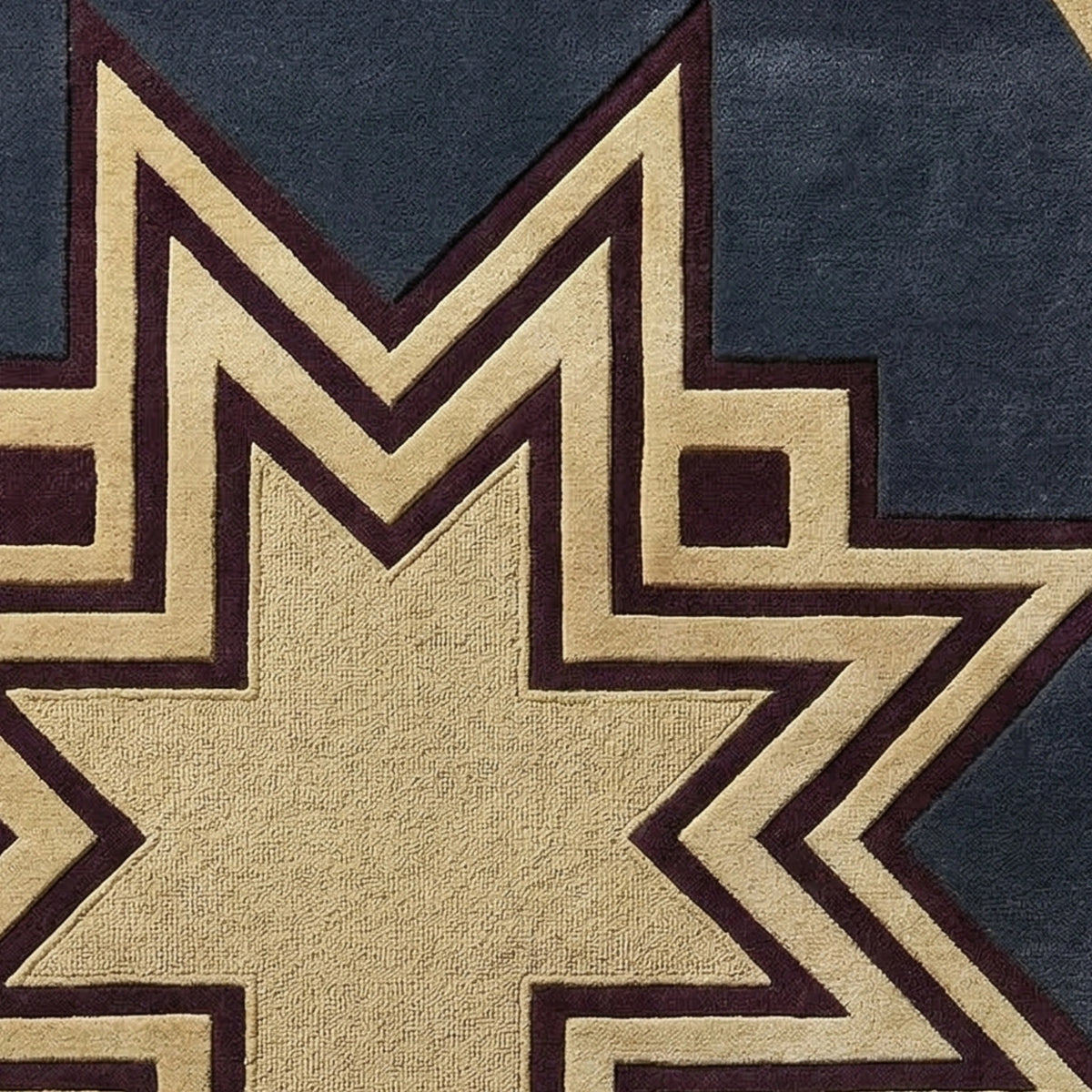 Close-up of a geometric patterned textile, likely a rug or fabric, featuring a large tan star shape outlined in dark brown, set against a dark navy blue background.