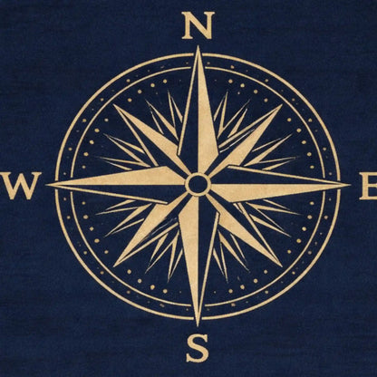 A navy blue fabric surface featuring a large gold compass rose design with cardinal directions N, S, E, and W.