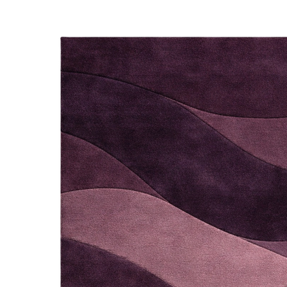 A close-up of a textured area rug featuring an abstract wavy pattern in shades of deep purple, plum, and mauve, shown against a plain white background.