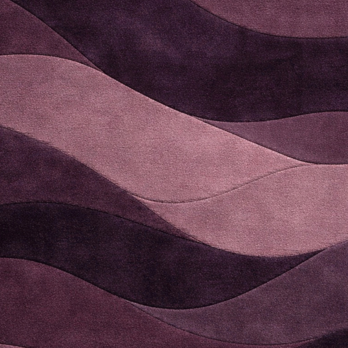 A close-up of a wavy, layered fabric or material surface in shades of purple and dusty pink, with a soft textured finish.