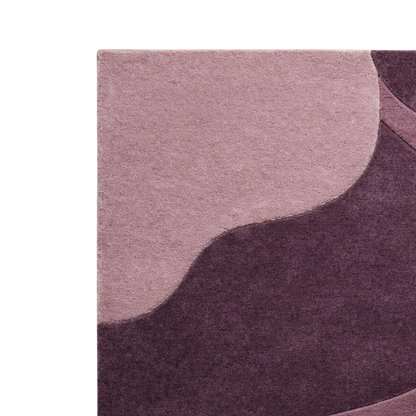 Close-up of a textured rug with an abstract wavy pattern in dusty pink and deep plum purple.