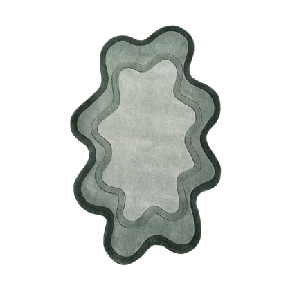 An abstract, wavy-edged rug or mat shown from above on a plain white background. The design features concentric layers in shades of gray and sage green, with a dark charcoal border.