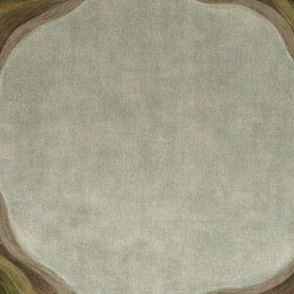 A close-up of a textured fabric or wallpaper swatch with a muted sage green center and a wavy border in brown, beige, and olive green.