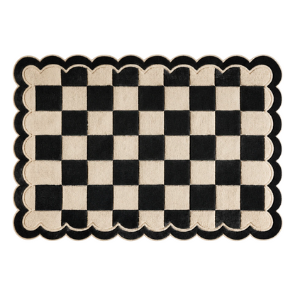 Black and cream checkerboard wool area rug with contrasting square pattern, rounded scalloped edges, and modern geometric design.