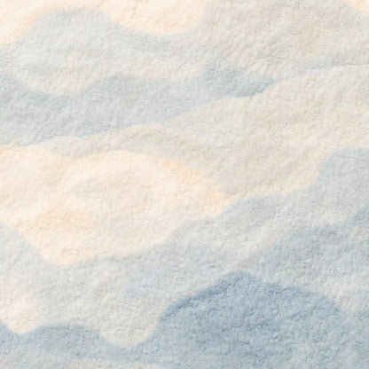 Close-up of a textured fabric with wavy pattern in light blue and beige.