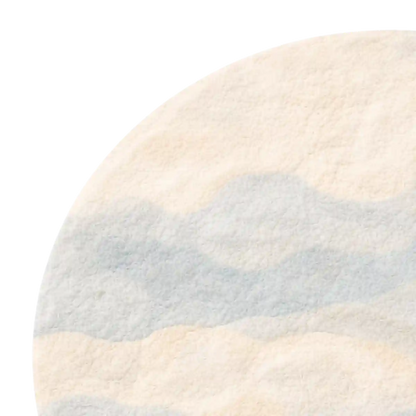 Round rug with a gradient design transitioning from beige to blue on a white background
